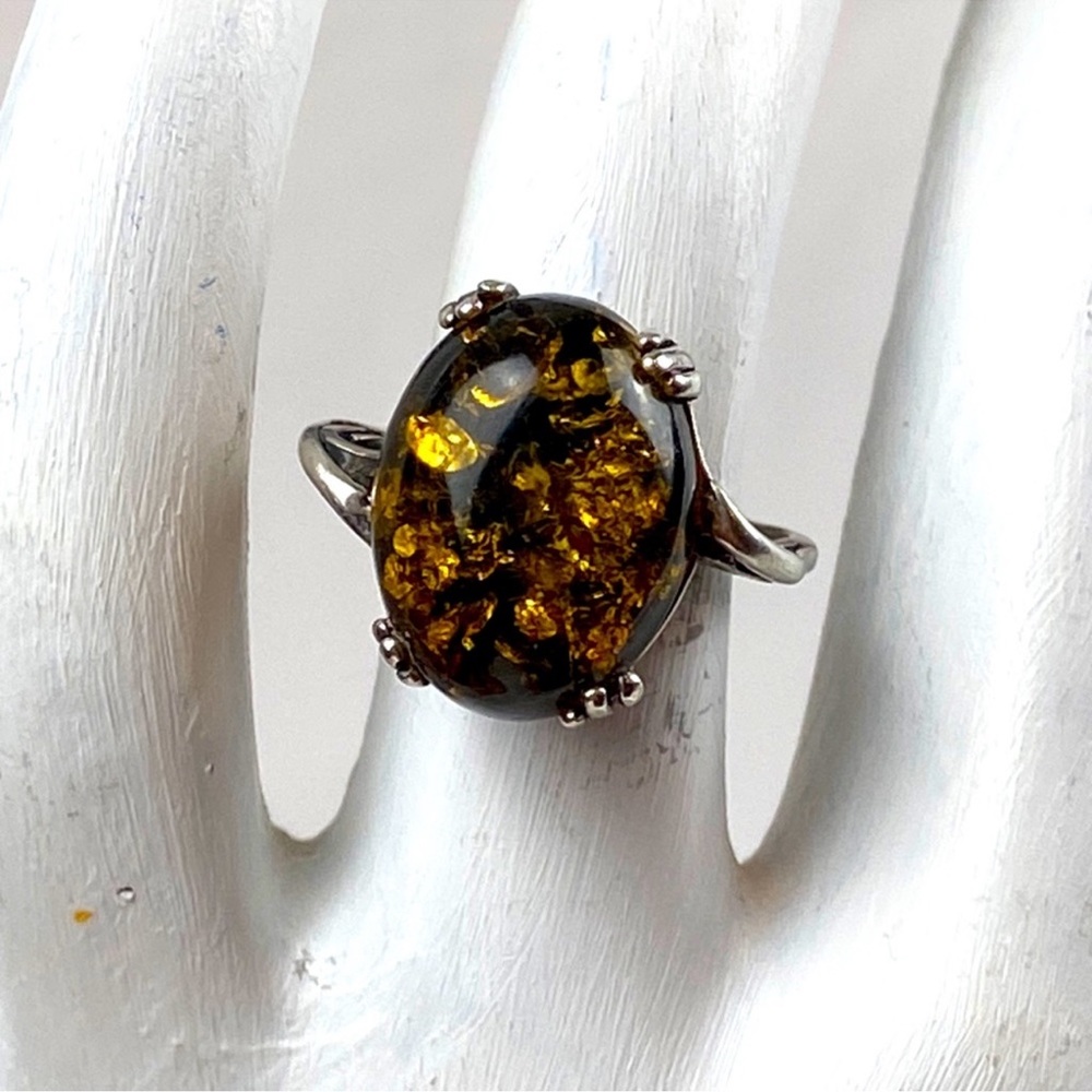 Large oval shape green amber ring on 925 silver ribbon swirl cage setting